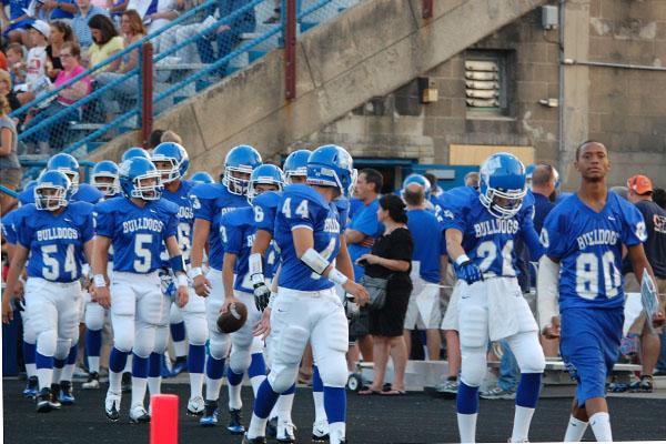 Lewis Rogers walks alongside his teammates as they stare down a 57-12 loss to St. Francis in the teams home opener.  The team went on to lose 42-0 in their next game against Lemont.