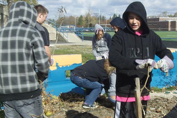 SEE Teamer Mac Catrambone and others stood in the Autumn chill to clear garden beds for a Fall garlic planting in the new End Zone Garden.