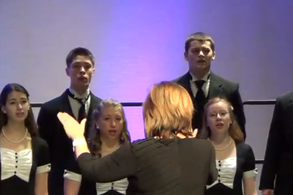 Fine Arts Department Chair and Madrigals sponsor Diane Marelli conducts the group at the IMEC in Peoria.  Marelli also acted as the piano accompanist for the event.