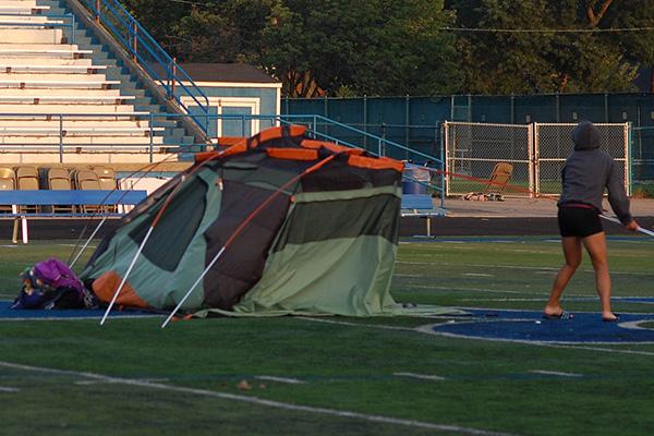 Lulu Keen takes down her tent after spending the night on the football field.