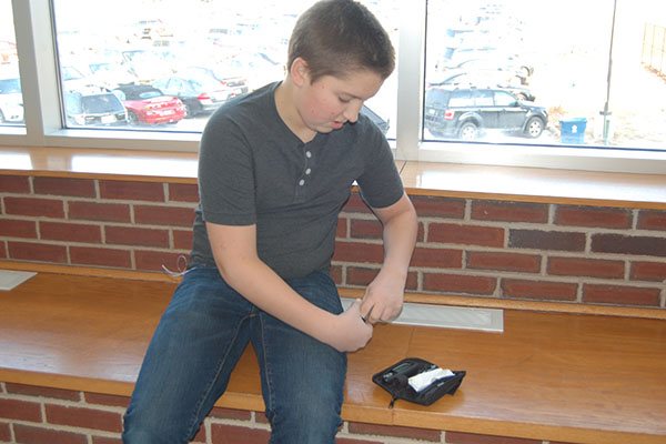 Freshman Joe Connelly tests his blood sugar.  Connelly is diagnosed with Type 1 diabetes.  Nevertheless, he competes on golf, participates on SEE Team, and plans on playing baseball.