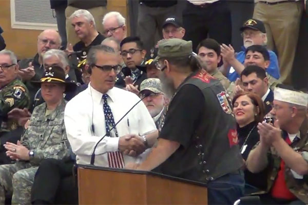 Veteran Dennis Wood hands a challenge coin to tearful Assistant Principal John Passarella.  Passarella is in his last year before retirement.  Wood thanked him for the service and leadership he has shown to RB.