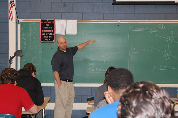 Bob Bensfield explains equations during an Algebra 2/Trig classes.  Bensfield co-teaches with Steve Yurek.  Currently, junior students choose between Algebra 2/Trig, a regular class, and Pre-Calculus, an honors class.