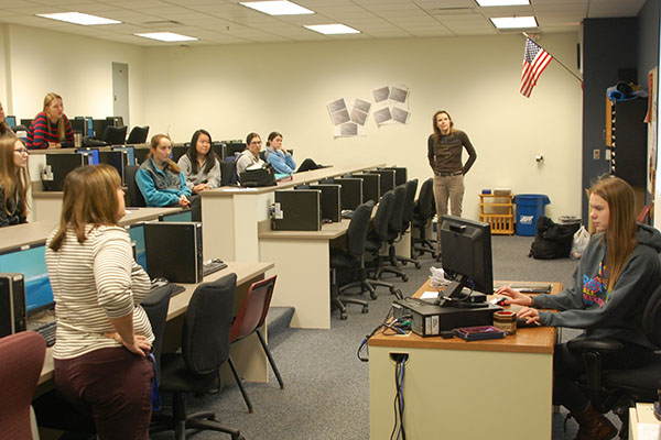 Sponsers of the brand new Girls who Code club Sandy Czajka (left) and Rutka Kulbis (far middle) view and critique club member Vasara Kulbis coding presentation. The Girls who Code meet Monday mornings before school in computer lab 252