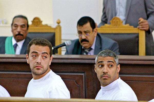 Cameraman Baher Mohamed, left, and Mohamed Fadel Fahmy, the Cairo bureau chief for al Jazeera English, look at reporters sitting behind them Monday, March 31, 2014, as Judge Mohamed Nagy listens to the defendants' complaints about the conditions they are being held in. Three Al Jazeera journalists, including Australian Peter Greste (not pictured) are standing trial on terror charges. (Amina Ismail/MCT)