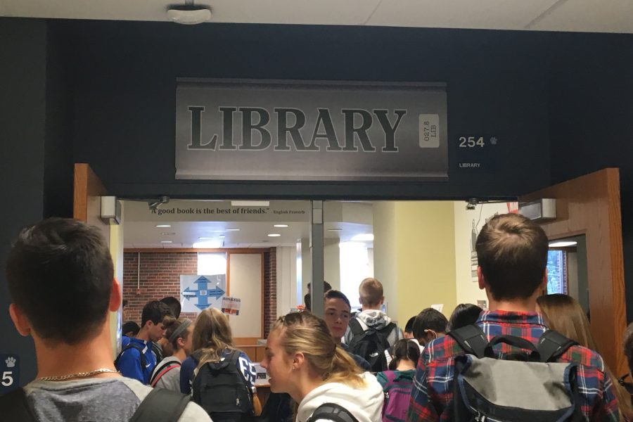 Students gather by library door waiting for it to open