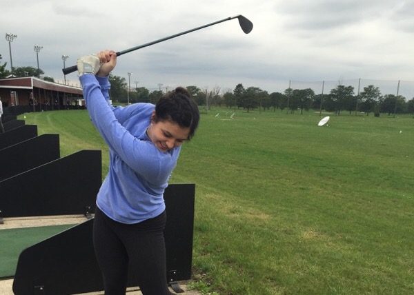 Senior Coco Murray practices her swing on a driving range.