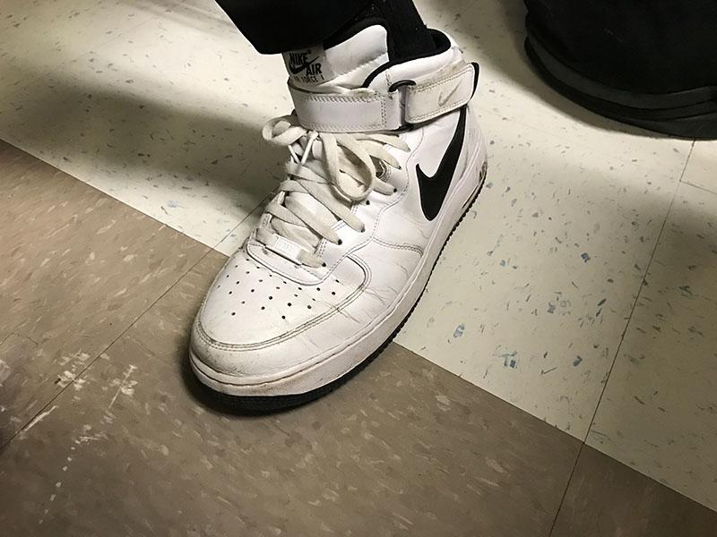 A students black and white Air Force 1s.