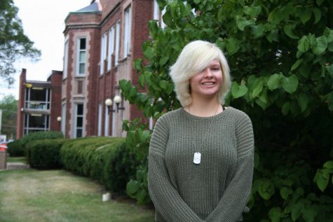 The rhyimng poet poses by the roses.