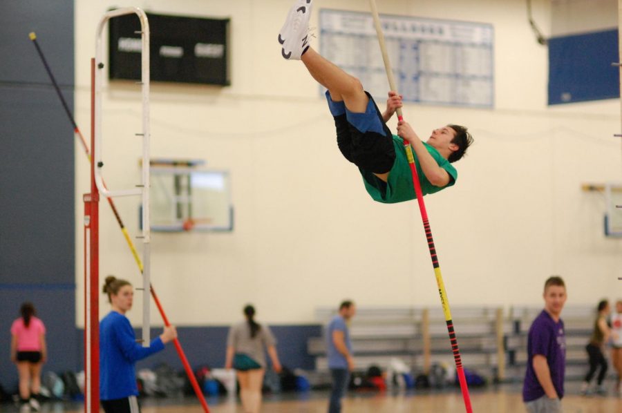Archer Teran in the middle of a pole vault jump.