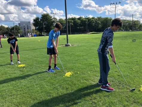 (From left to right) Andrew Agne, Evan Braniff,  and Trevor DeButch line up to putt in a JV practice. 