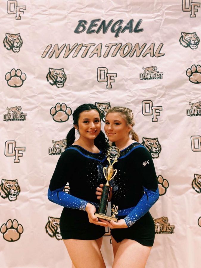Cerny (on the right) posing with a teammate at a competition in Oak Forest while holding a trophy. 