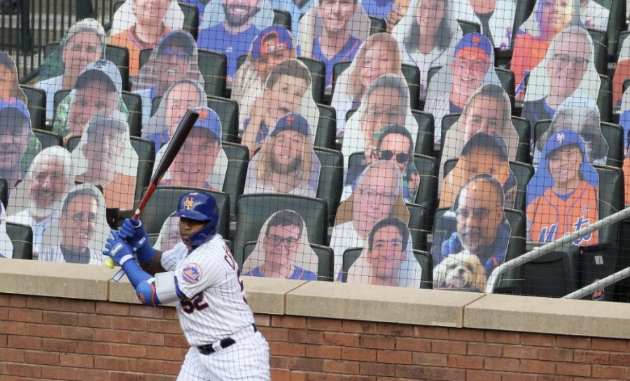 Yoenis Cespedes of the New York Mets standing practicing his swing in front of cardboard cutouts of fans.
