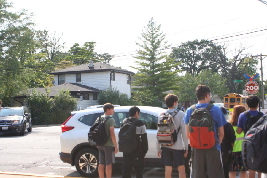 Students wait to cross the street in the after school traffic.