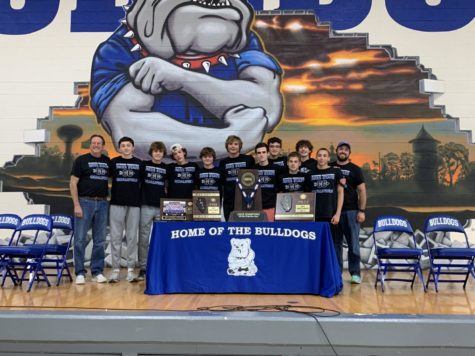 RBs boys cross country team pose with their trophy after pep rally.