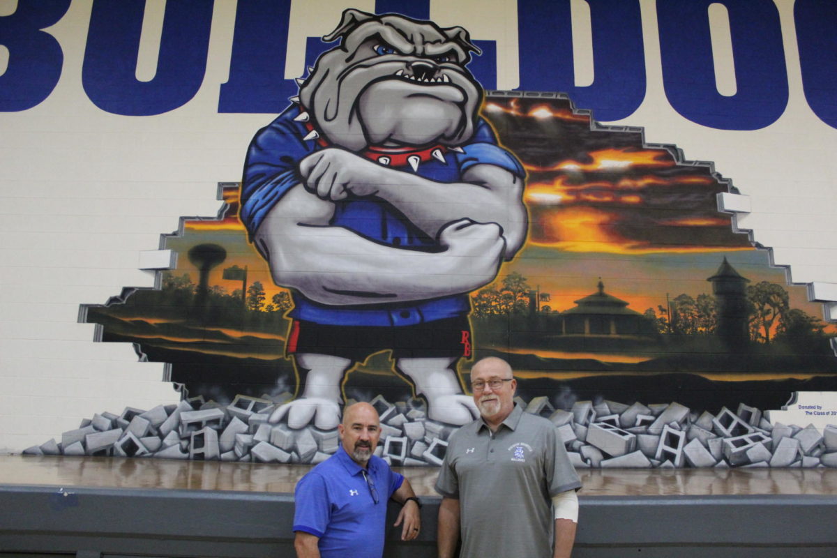 Jones and Domin pose in front of bulldogs mural.