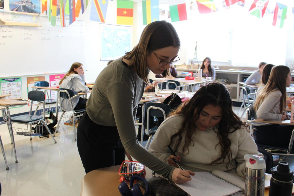 Ms. Moorehouse working with a student in the French classroom.