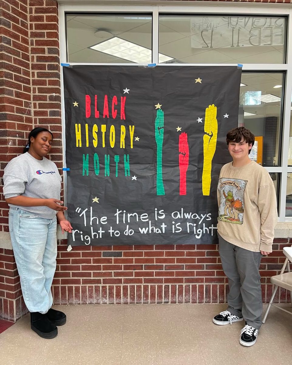 Students standing in front of a Black History Month banner in the Atrium. Photo courtesy of Daniel Rubio.